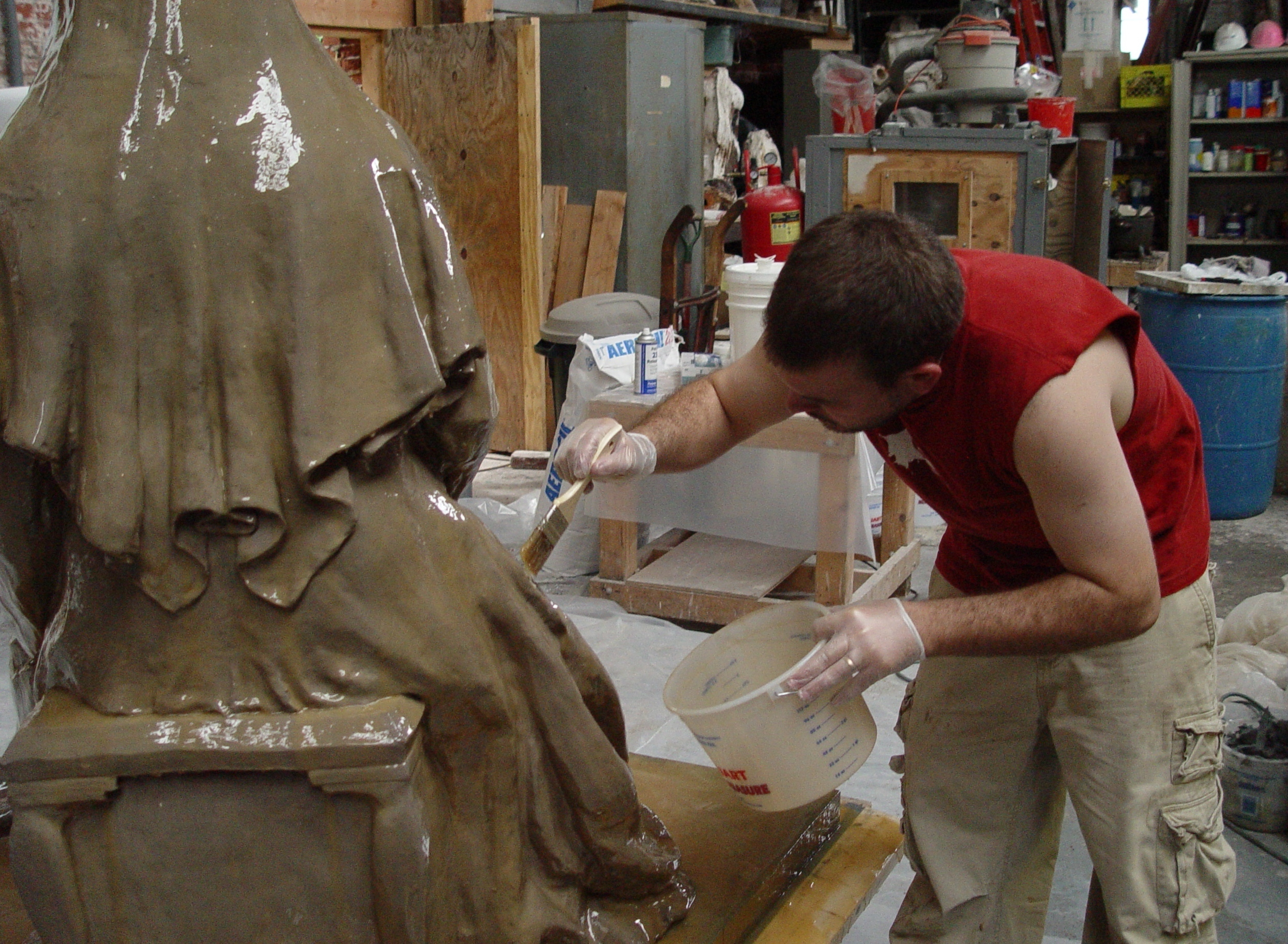 Zachary Kainz is applying the first coat of the rubber mold