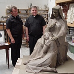 Fr. Kelly and Fr. Lucas are looking at the statue in clay